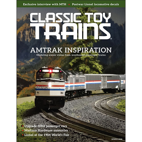 Magazine cover featuring a model train set with Amtrak locomotive on a scenic track.