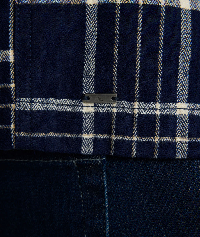 Model is wearing UNTUCKit Whitaker plaid over shirt in navy.