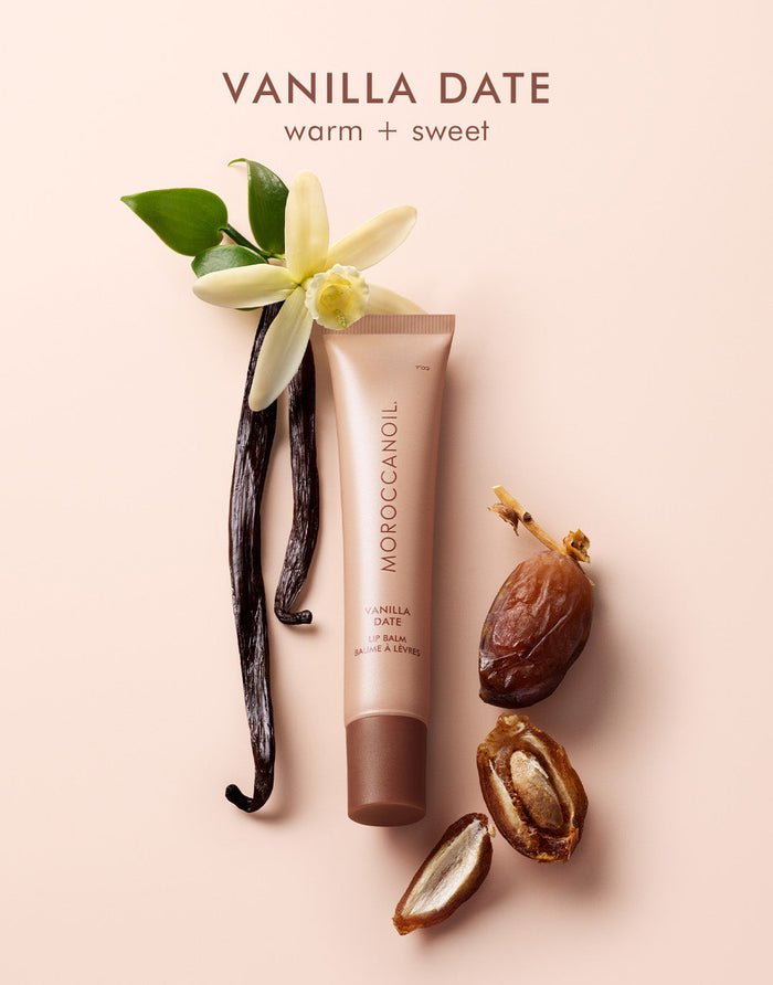 Argan Butter Lip Balm | Moroccanoil tube surrounded by vanilla flower, vanilla pods, and date fruit, highlighting warm and sweet skincare ingredients.