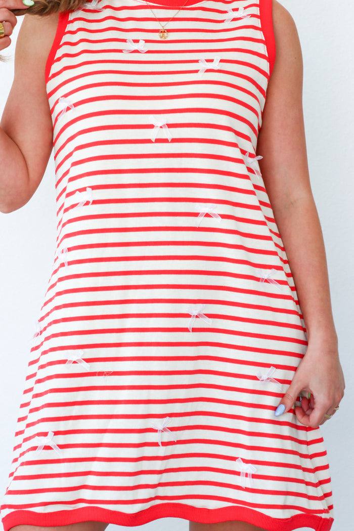girl wearing red striped dress with bow detailing