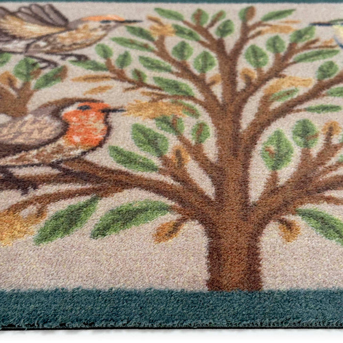 Close-up of Chorus Birds Beige Charity Doormat showing pile height and green blue border.