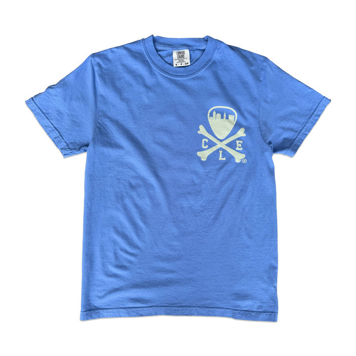 A blue short-sleeve crewneck t-shirt with a distressed white graphic on the left chest featuring a shield, crossbones, and the letters 'C L E'.