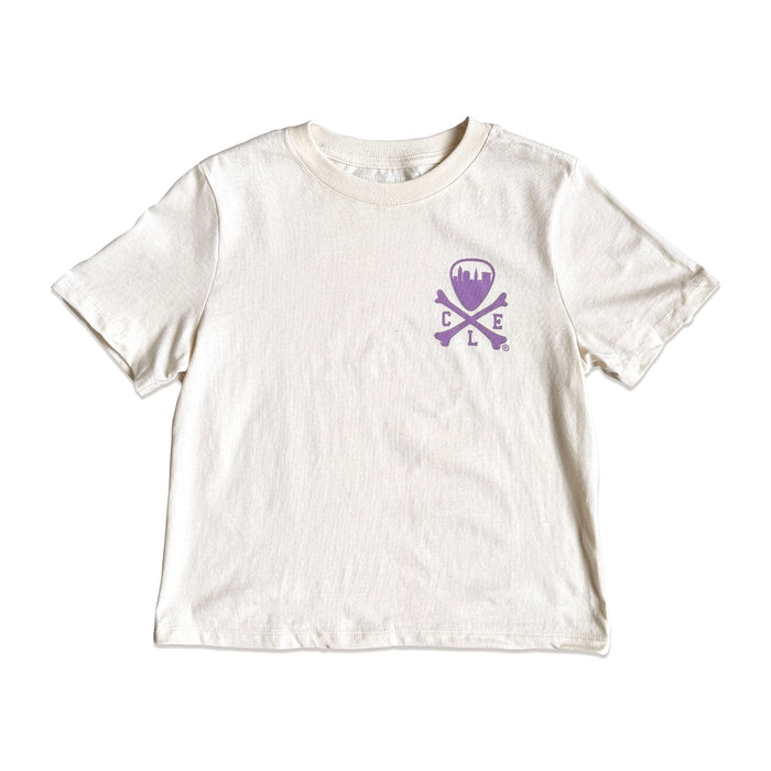An off-white short-sleeve crewneck t-shirt featuring a purple skull and crossbones graphic on the left chest with the letters 'D', 'E', and 'L' integrated into the design.