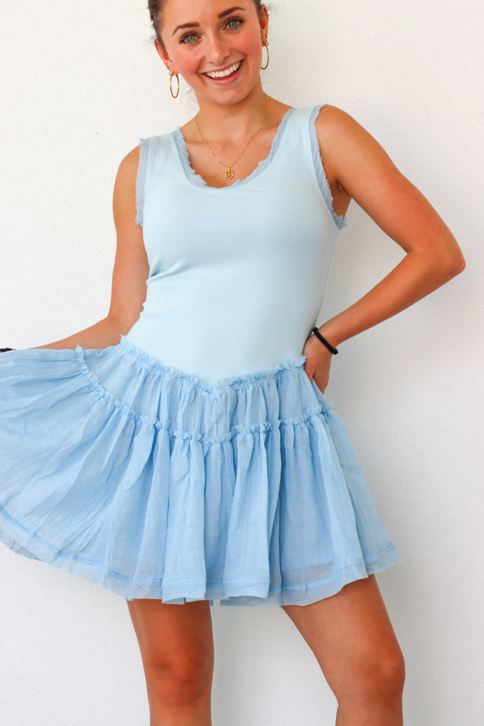 Woman wearing a light blue dress with a white background