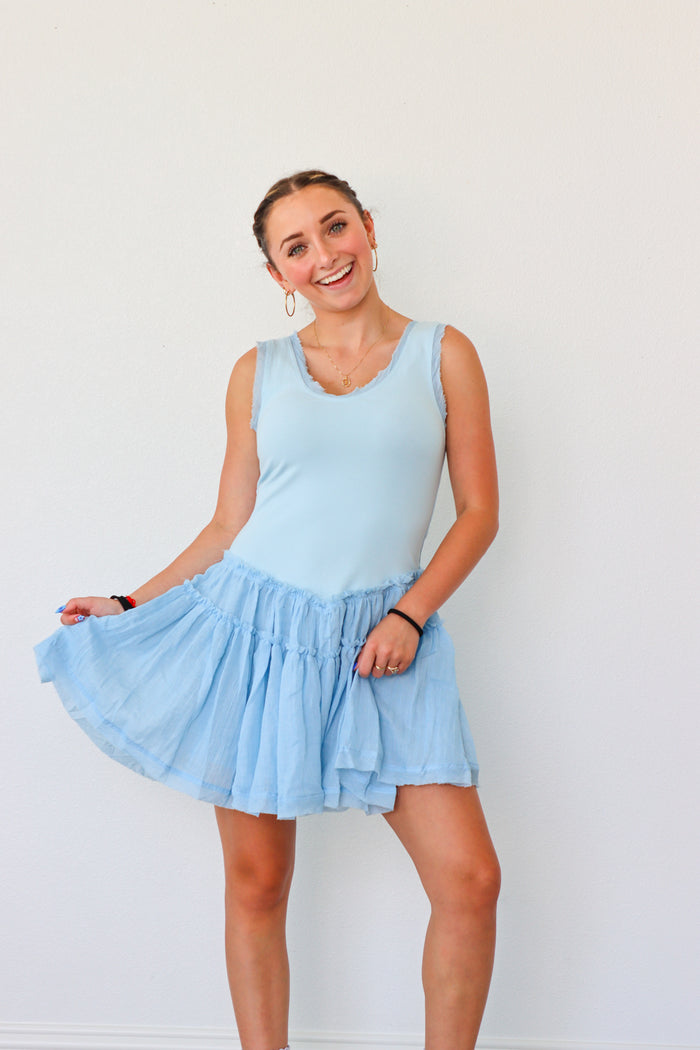 Woman wearing a light blue dress against a white background