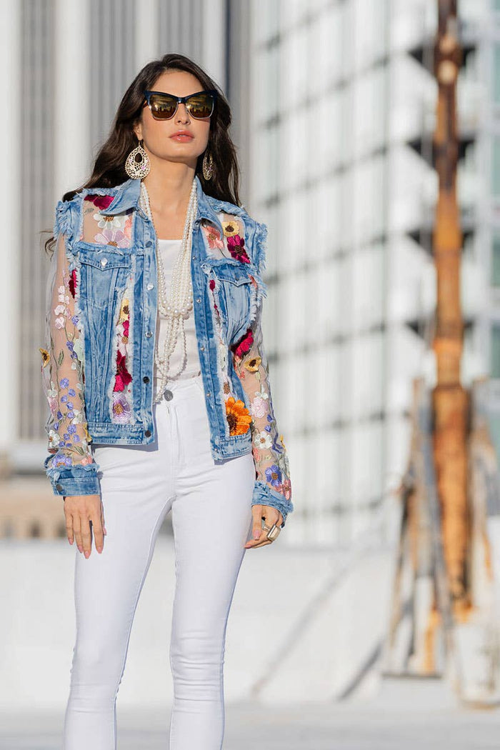 Woman in floral denim jacket and white pants