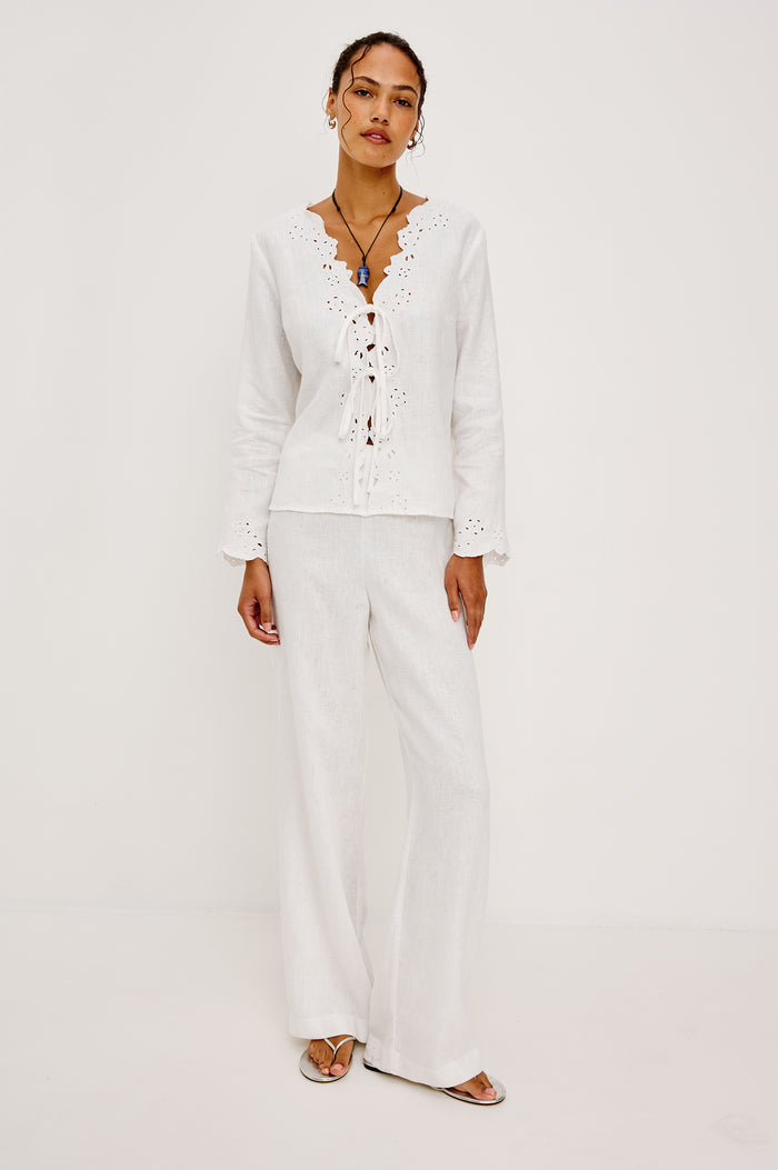 Fleur Top in Linen With Floral Eyelet Embroidery Open Front Adjustable Front Self-Ties Long Sleeves and Loose Fit in White - Full Body Front View Featured on Model