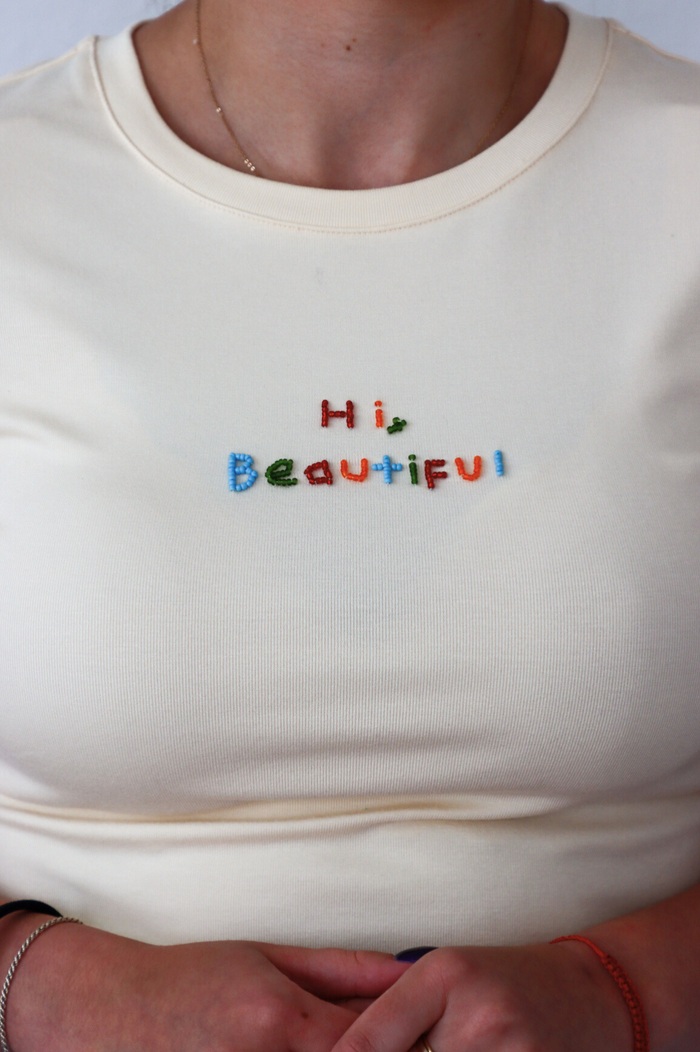 girl wearing cream "hi beautiful" graphic tee