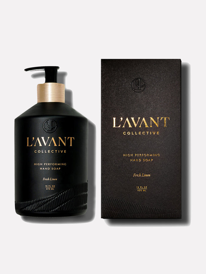 Bottle and box packaging of High Performing Hand Soap - Fresh Linen | L'AVANT Collective in sleek black design with gold lettering, showcasing skincare product.