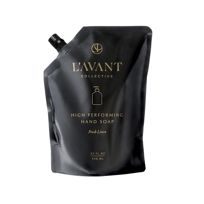 Black flexible refill pouch of High Performing Hand Soap Refills | L'AVANT Collective with gold lettering and a spout cap, labeled Fresh Linen scent for skincare and body care.