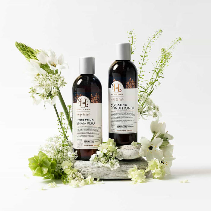 Two bottles of shampoo and conditioner with flowers on a white background