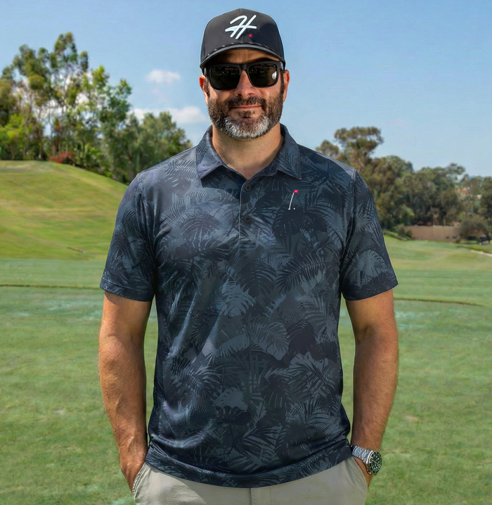 Man wearing Performance Men's Golf Polo with Various Shades of Blue and Gray Jungle Palm Fronds