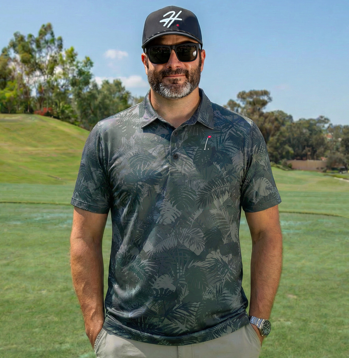 Man wearing Performance Men's Golf Polo with Various Shades of Gray and Green Jungle Palm Fronds