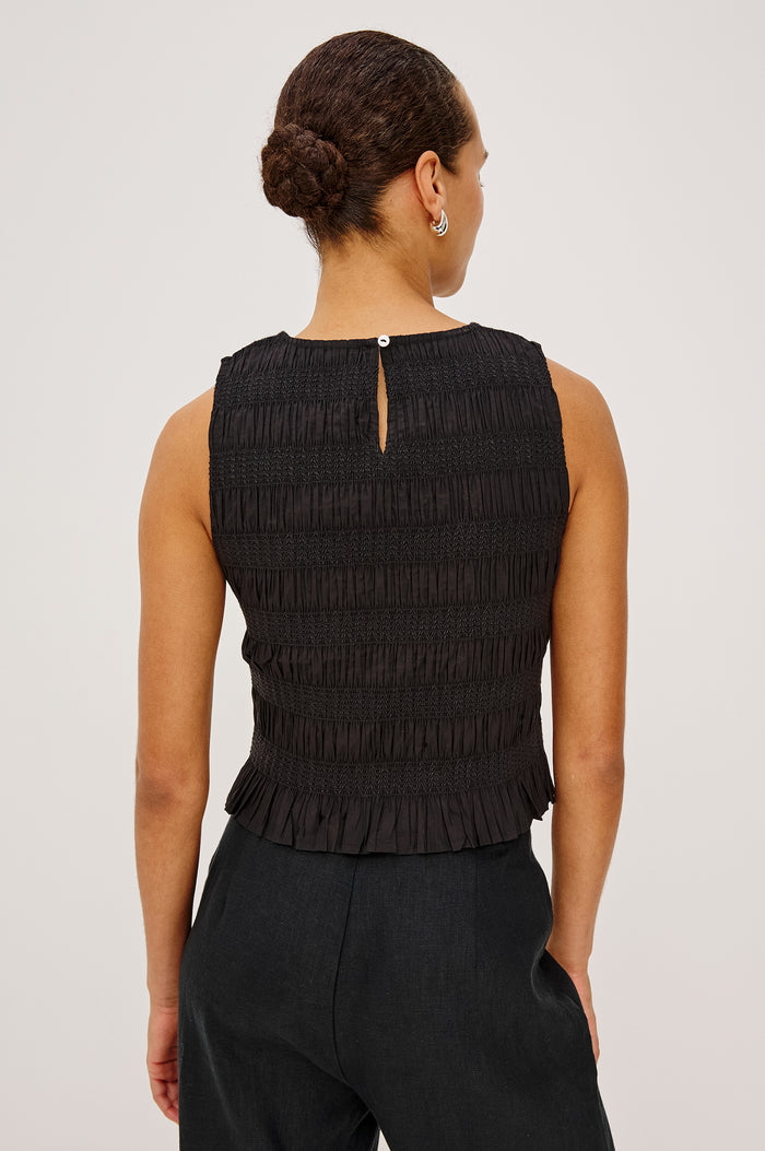 Kane Sleeveless Fitted Top in Cotton With Diamond Smocking All Over, High Boat Neckline, and Flared Ruffle Hem in Black Colorway - Upper Body Back View Featured on Model