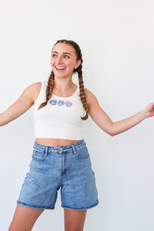 girl wearing white cropped tank top with seashell graphics