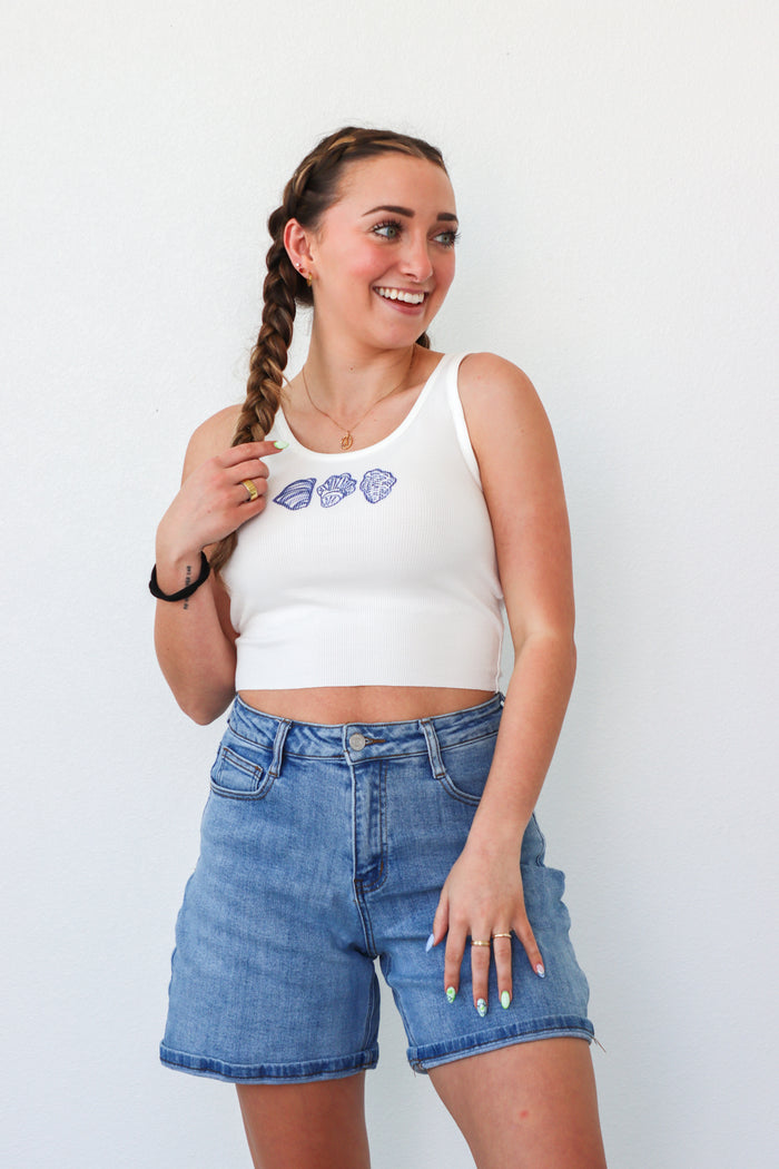 girl wearing white cropped tank top with seashell graphics