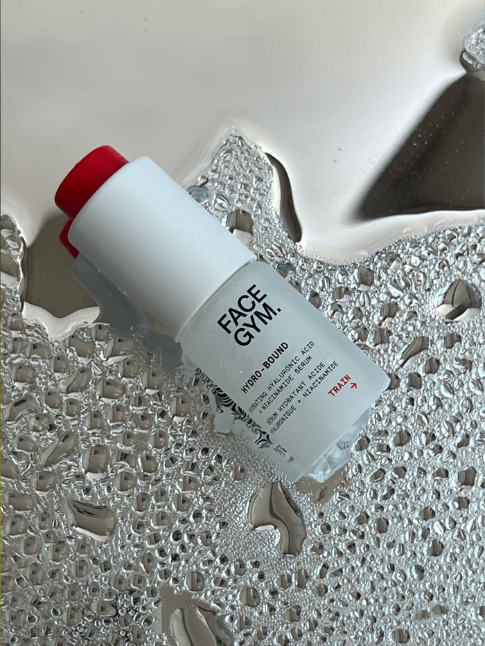 a white bottle with red cap on a silver surface