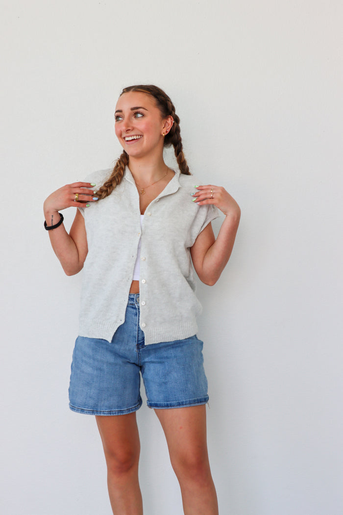 girl wearing light gray short sleeved cardigan