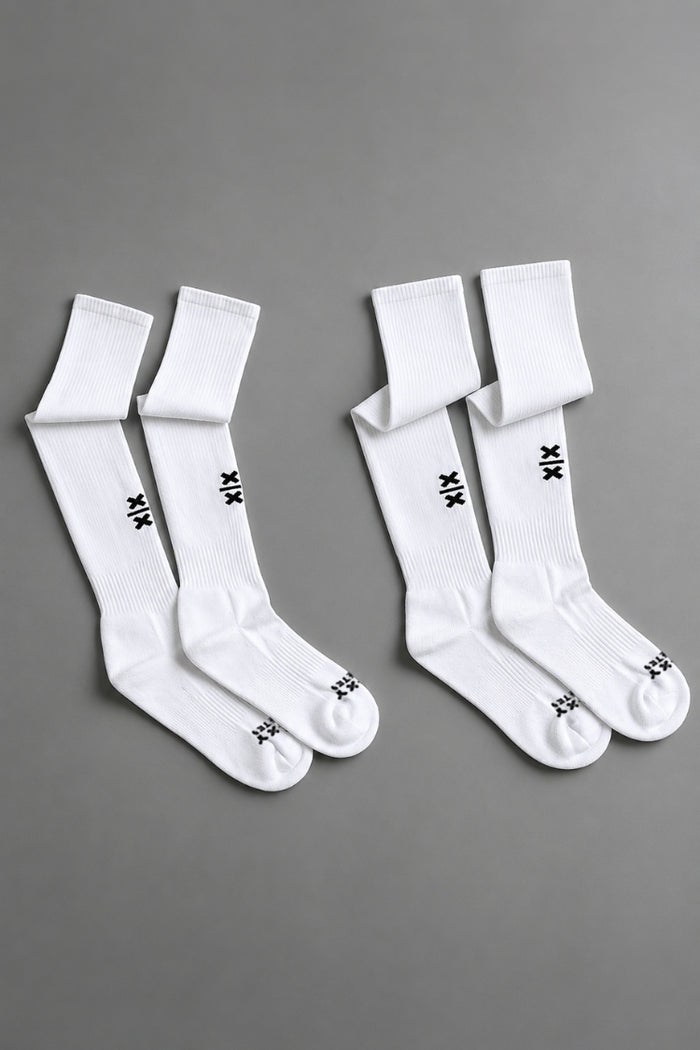 Two pairs of white socks with black branding on a gray background || White