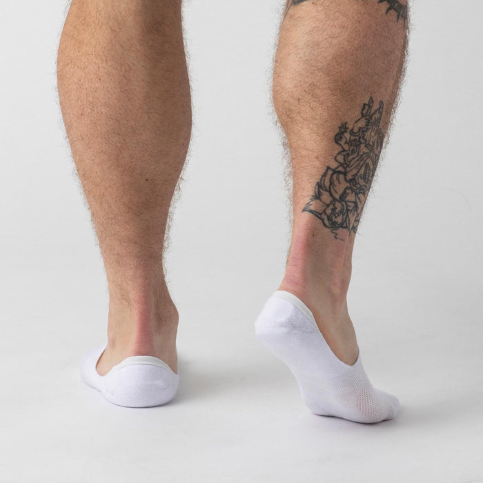 White Never Show Socks 3-Pack on male model's feet, tattoo visible.