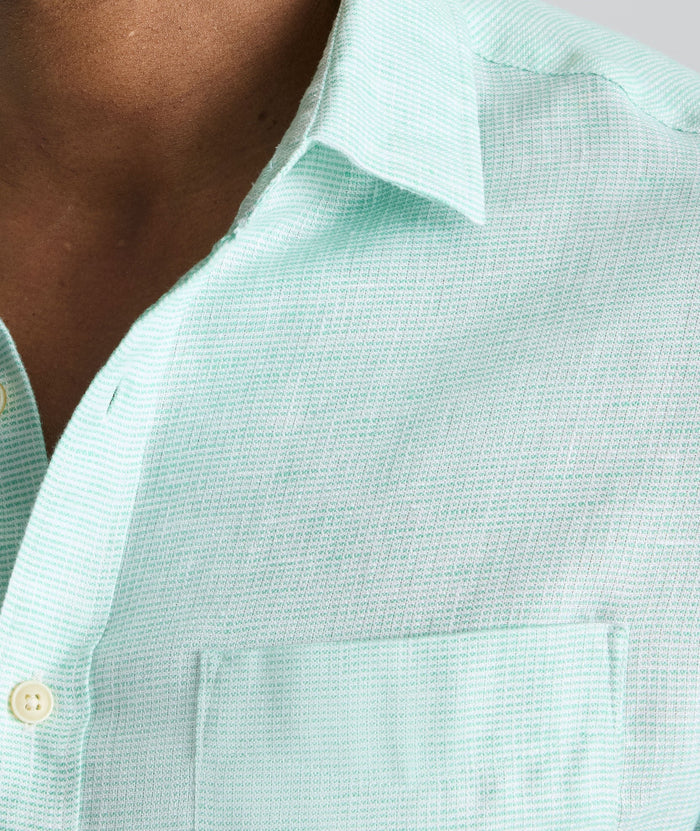 Model is wearing UNTUCKit Wrinkle-Resistant Linen Wildehart Shirt in green.