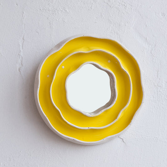 Handmade yellow ceramic mirror with layered organic shapes and orange glazed edges